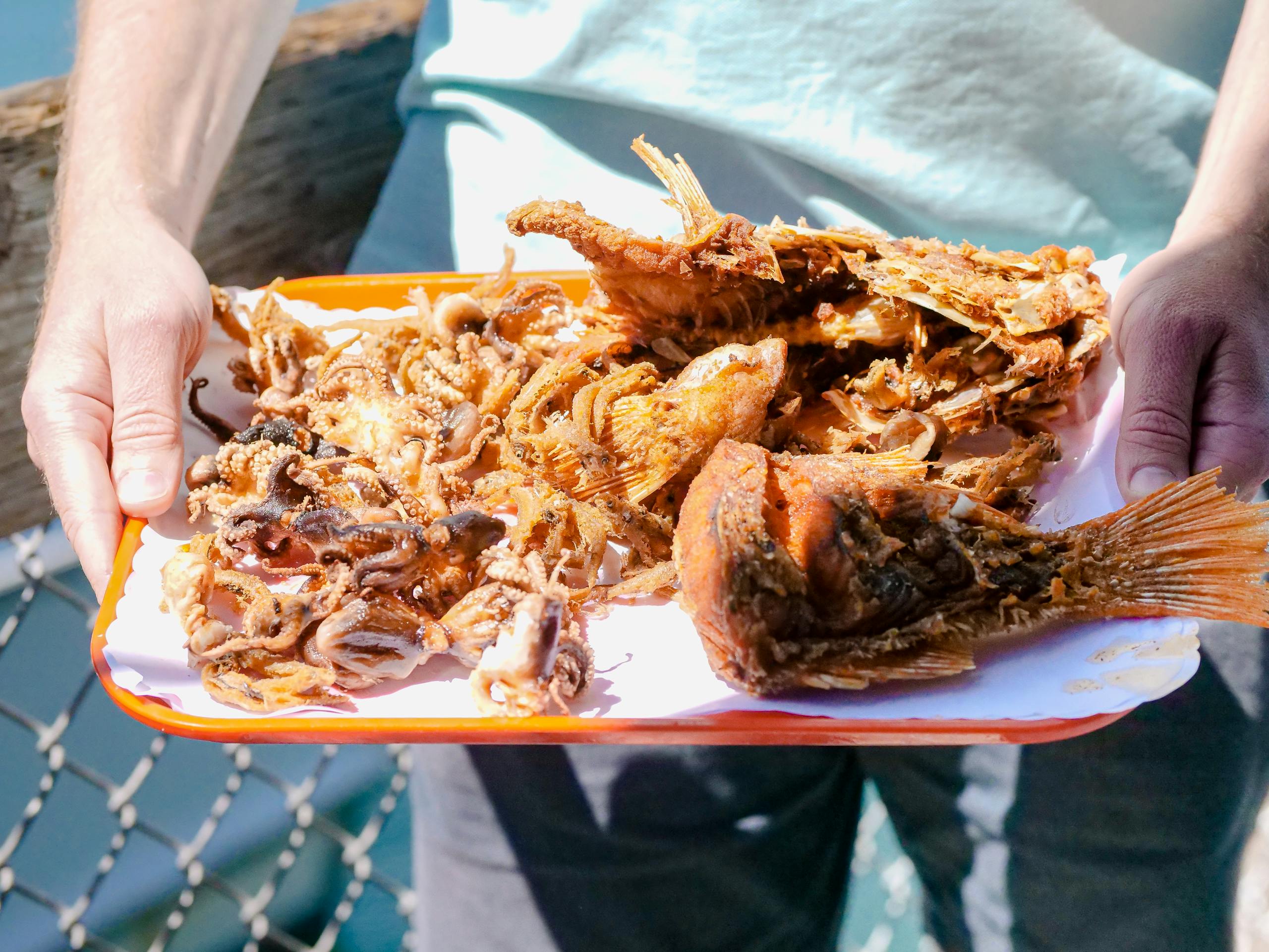 A tray of grilled seafood including fish and octopus, perfect for a summer meal.