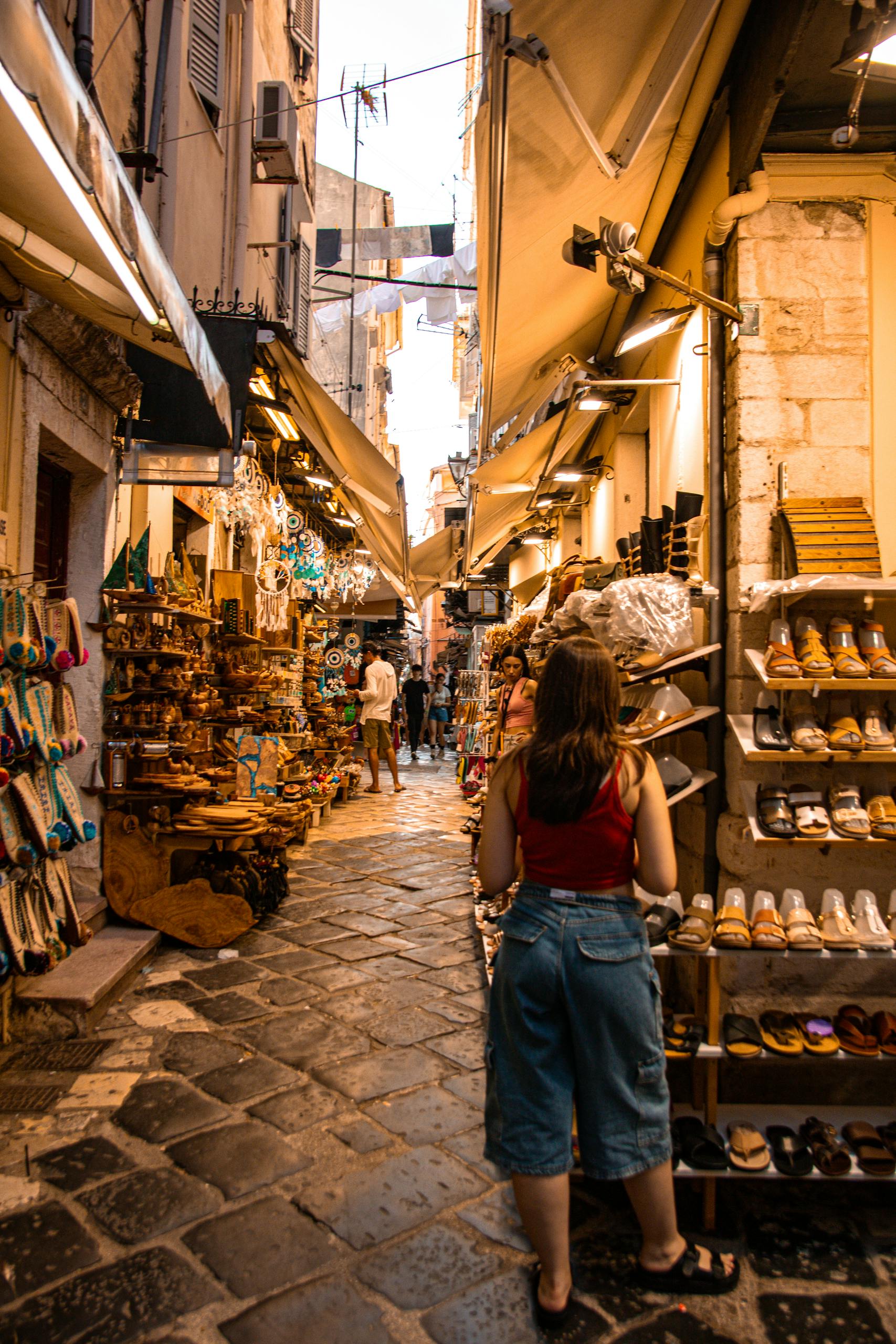 Discover the vibrant streets of Corfu, Greece, adorned with local shops under warm sunset lighting.