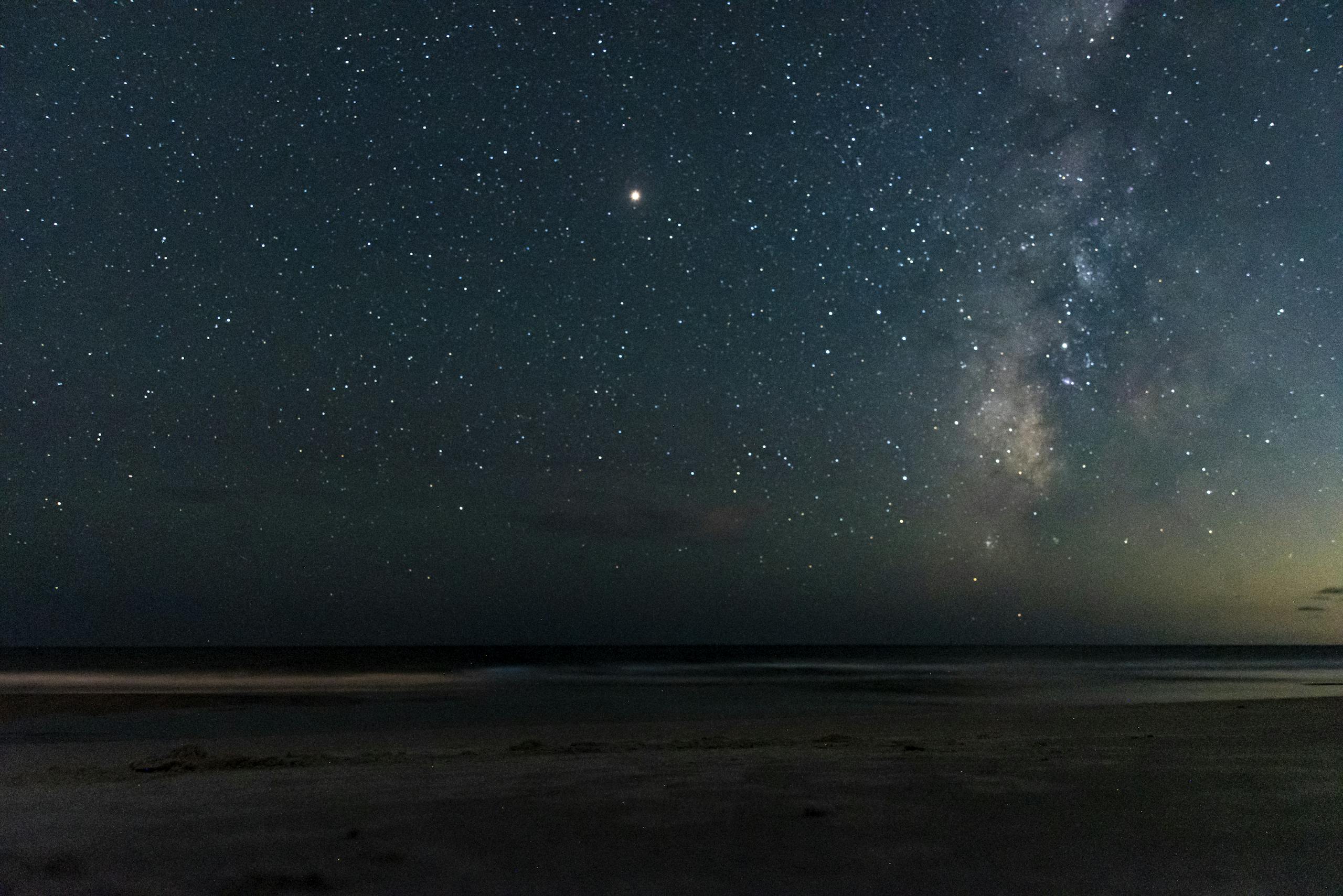 A breathtaking view of the starry night sky above Oak Island beach, showcasing the Milky Way.