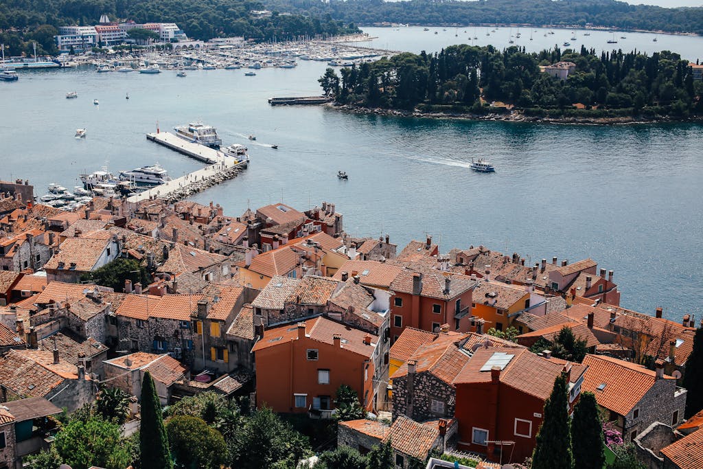 A picturesque aerial view of a coastal town with colorful rooftops and a marina by the sea.