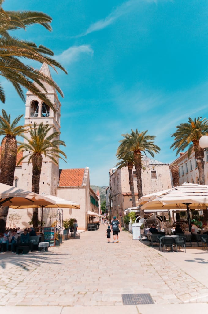 Explore the vibrant Trogir promenade with palm trees and cafes in Split-Dalmatia, Croatia.